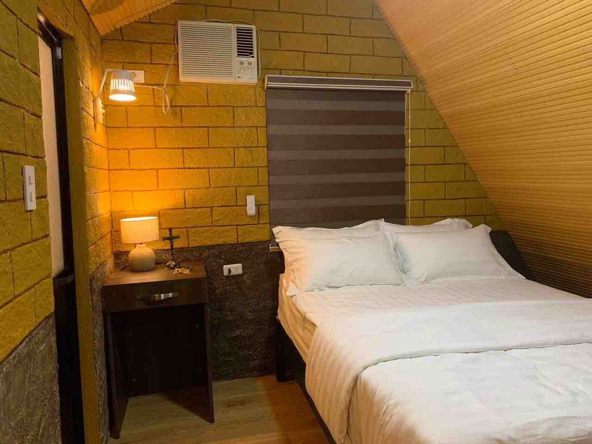 Cozy cabin bedroom with warm lighting and A-frame ceiling
